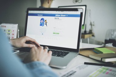 dizüstü bilgisayarda Facebook uygulaması kullanan kadın