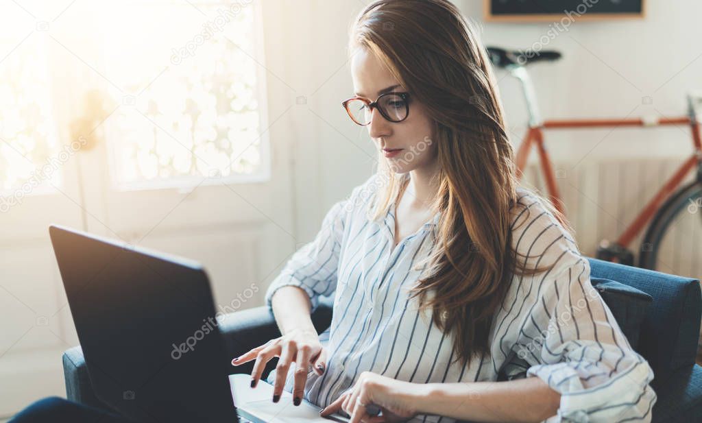 Hipster girl using laptop at home 