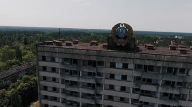 Ölü kentin Pripyat cephesinde Sovyet arması ile çok katlı bina terk. Hayalet kasaba Chernobyl bölgedeki.