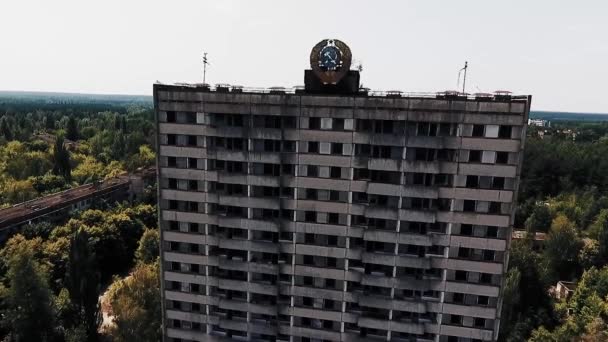 Abandoned multi-storey building with the Soviet coat of arms on the facade in the dead city of Pripyat. Ghost town in the Chernobyl zone. — Stock Video