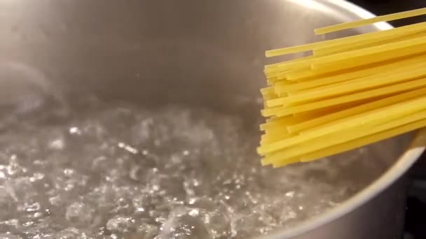 水を沸騰のスパゲッティの準備のクローズ アップ。スローモーションでパスタを準備します。 — ストック動画