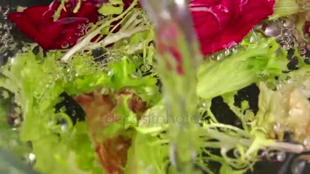 Water wordt gegoten in glazen kom. Gieten van water in een glazen kom vol natuurlijke salades. — Stockvideo