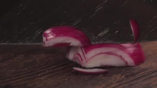Las manos masculinas cortan cebolla jugosa fresca en una tabla de madera con un cuchillo afilado. Corte de cebolla roja en tabla de madera. De cerca. . — Vídeos de Stock