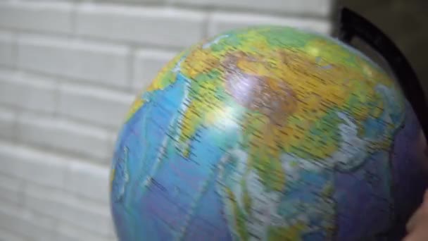 L'homme tourne un globe et le pointe du doigt. L'homme choisit son prochain voyage sur un globe tournant . — Video