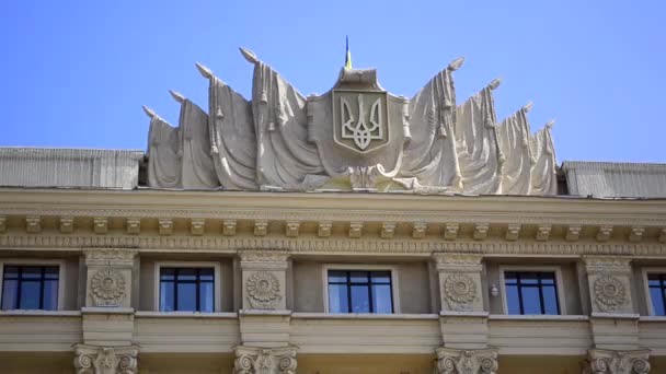 Das ukrainische Emblem und die ukrainische Flagge auf dem Portikus des Gebäudes. Ukrainisches Regierungsgebäude. Charkiw — Stockvideo