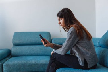 kız kanepede smartphone ile