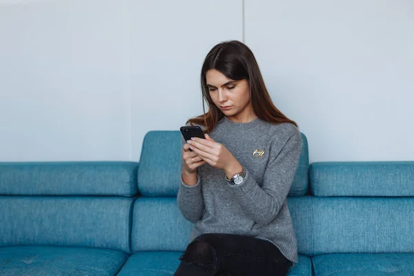 girl with smartphone on the sofa