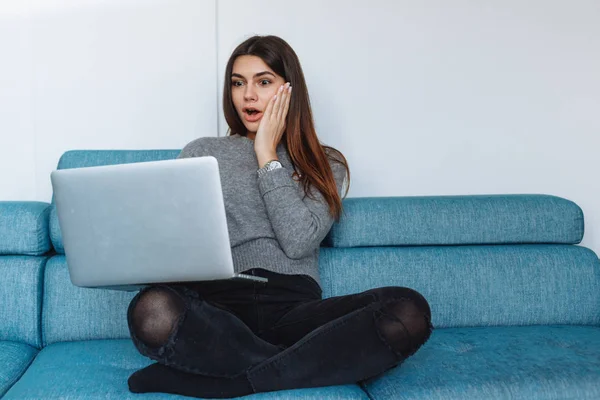 girl with laptop on the sofa and white wall