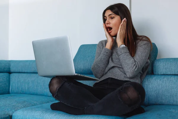 girl with laptop on the sofa and white wall