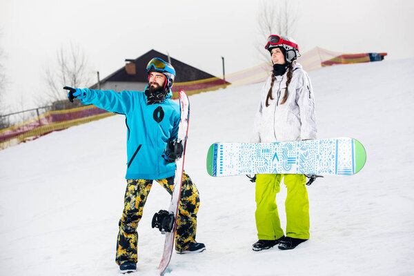 Young couple of snowboarders