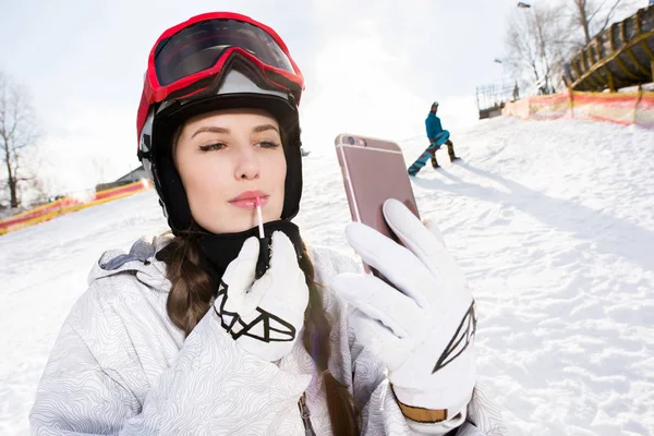 Snowboarderin trägt Lipgloss auf — Stockfoto