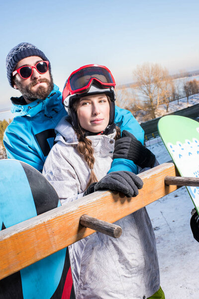 Couple of snowboarders embracing
