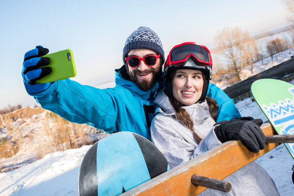 Snowboarders making selfie  