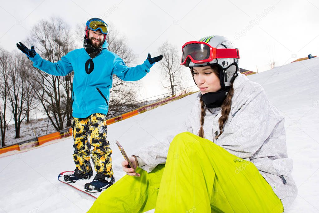 Female snowboarder using smartphone