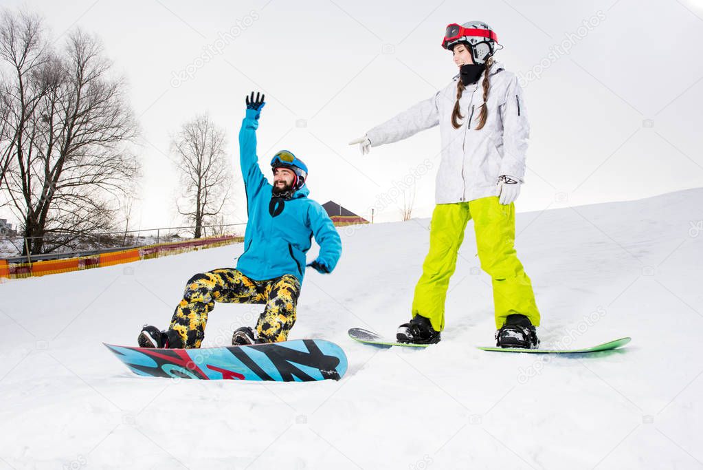 Young couple of snowboarders