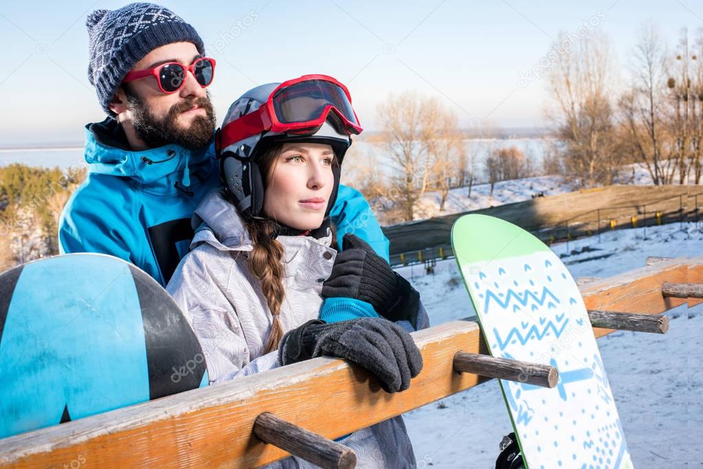 Couple of snowboarders embracing