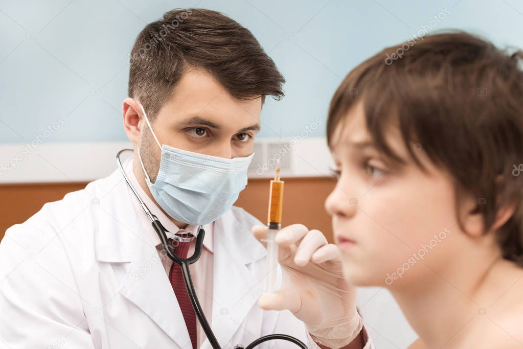 Doctor making injection to boy