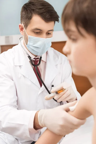 Doctor making injection to boy — Stock Photo