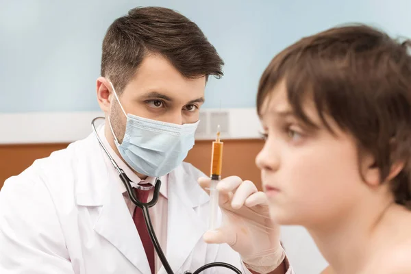 Doctor making injection to boy — Stock Photo