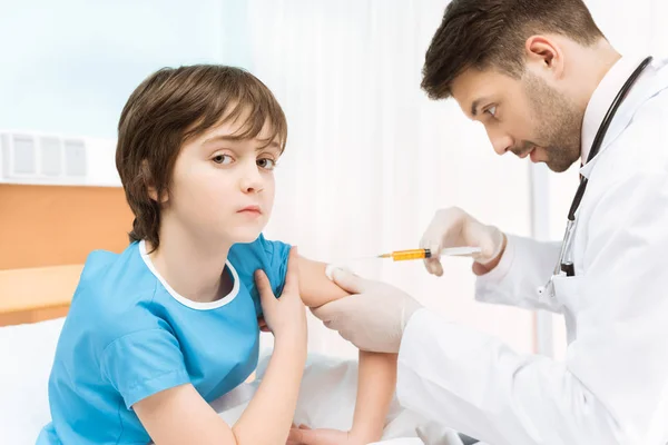 Doctor making injection to boy — Stock Photo
