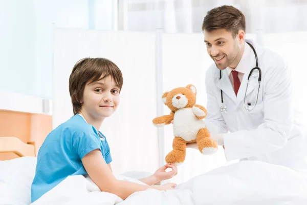 Niño paciente con osito de peluche - foto de stock