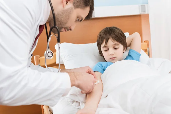 Médico haciendo inyección a niño - foto de stock