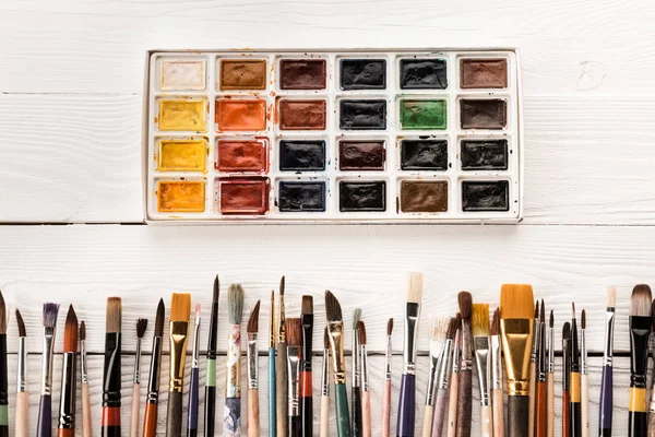 Various paintbrushes and paints — Stock Photo