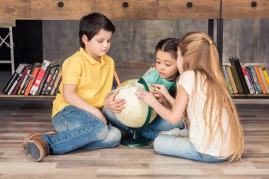 children with globe in library