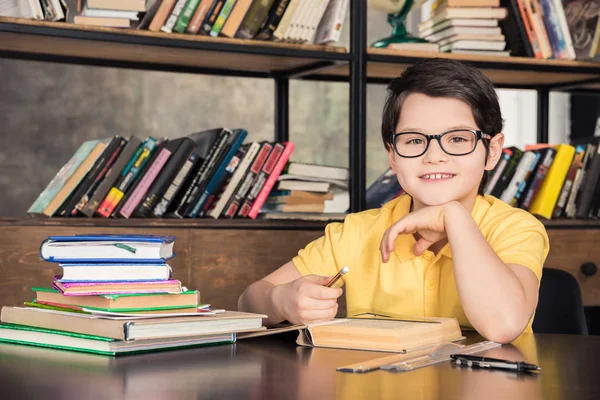 Schoolboy studying in library — Stock Photo, Image