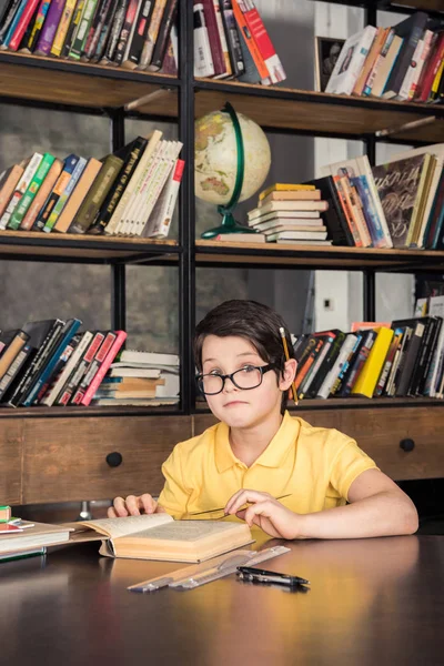 Schoolboy studying in library — Stock Photo, Image