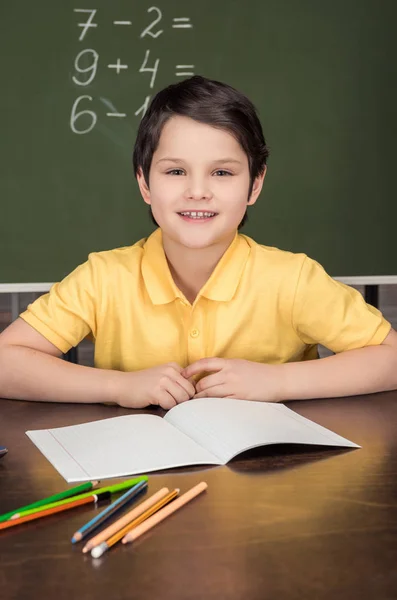 Chłopiec siedzi przy stole w klasie — Darmowe zdjęcie stockowe