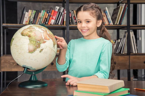 Mädchen mit Globus in Bibliothek — Stockfoto