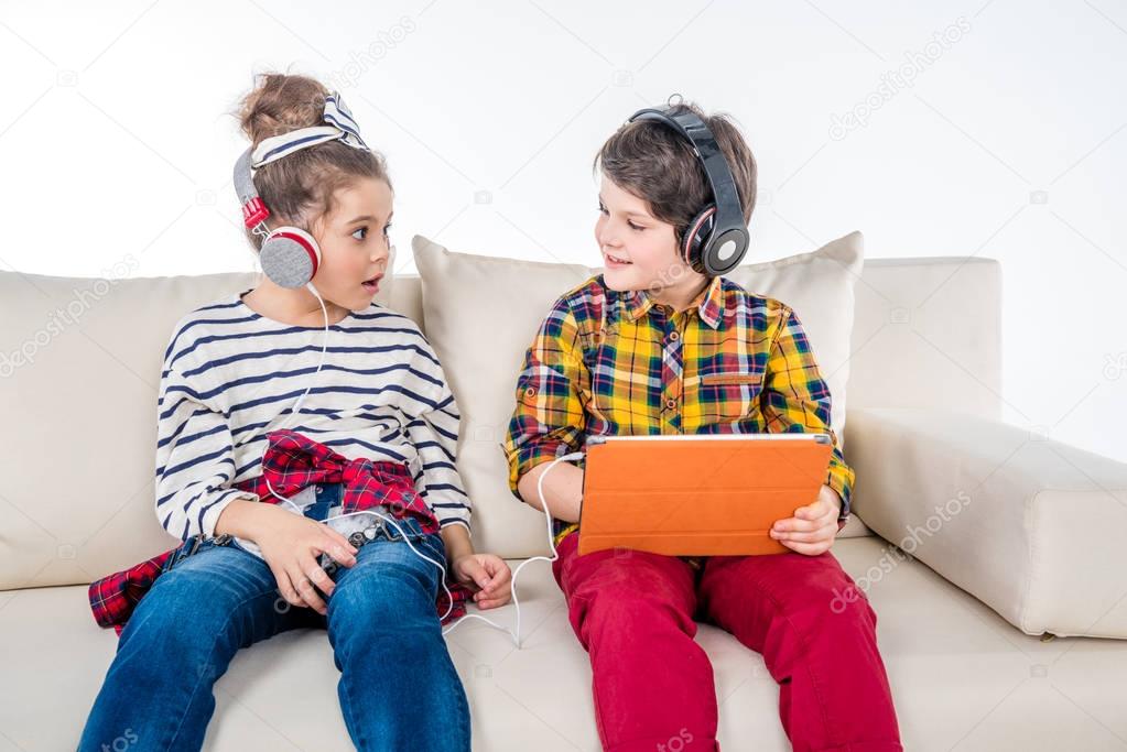 Children with headphones and digital tablet