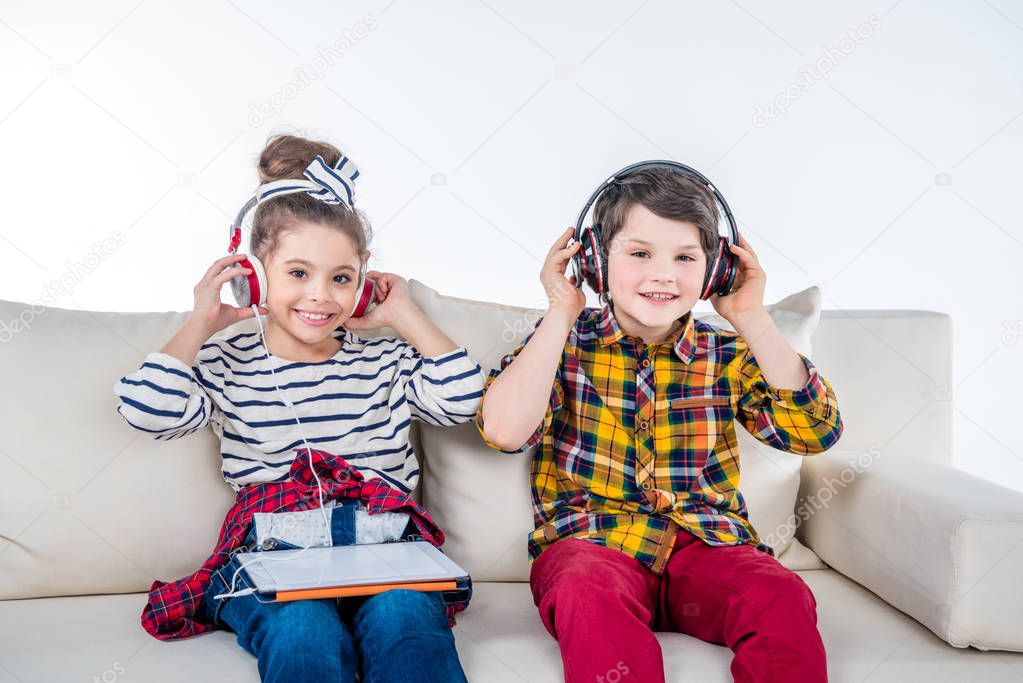 Children with headphones and digital tablet