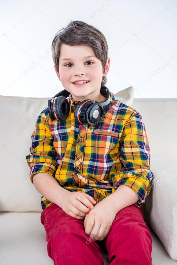 Boy with headphones sitting on sofa
