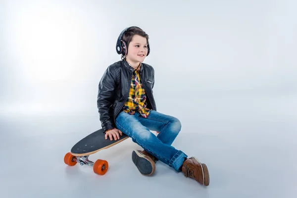 Jongen in hoofdtelefoon met skateboard — Stockfoto