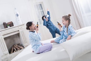 Kids in pajamas playing  clipart