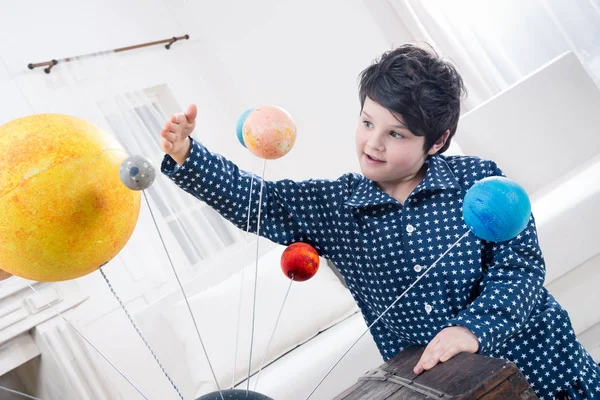 Pojken tittar på planeter modeller — Stockfoto