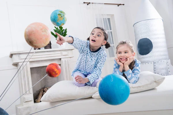 Meisjes kijken naar planeten modellen — Stockfoto