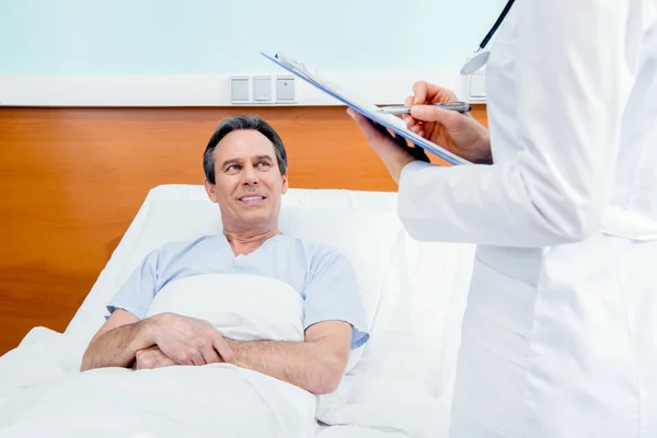 Patient and doctor with diagnosis — Stock Photo, Image