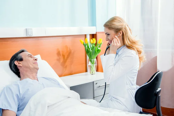 Doctor examining patient with stethoscope — Stock Photo, Image