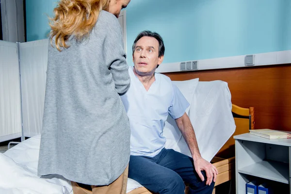 Mann sitzt auf Krankenhausbett — Stockfoto