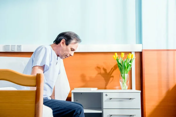Мужчина сидит на больничной койке — стоковое фото