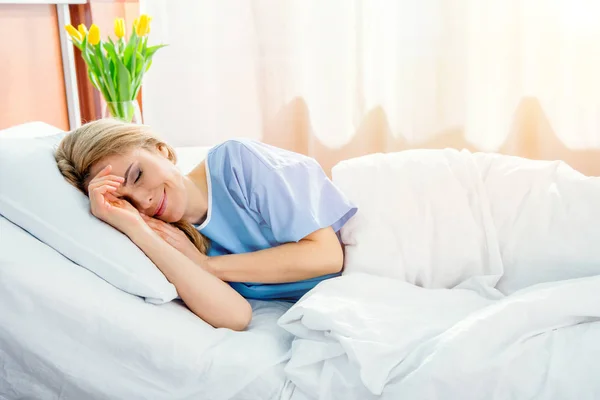 Женщина лежит на больничной койке — стоковое фото