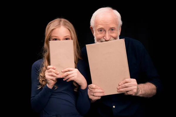 Grandfather and granddaughter holding books — Stock Photo, Image