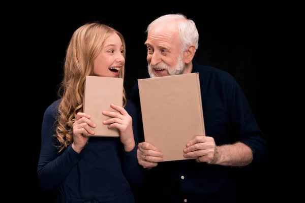 Grandfather and granddaughter holding books — Free Stock Photo