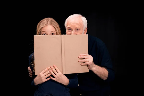 Grandfather and granddaughter holding book — Stock Photo, Image