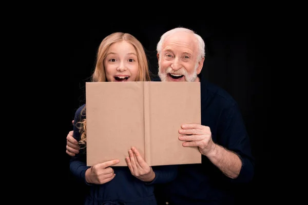 祖父と孫娘の本を保持しています。 — ストック写真