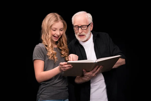 Grandfather and granddaughter with book — Free Stock Photo