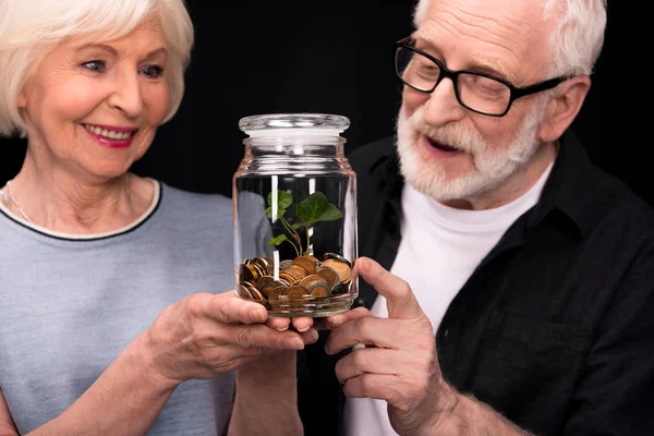 Couple with coins and plant in jar — Stock Photo, Image